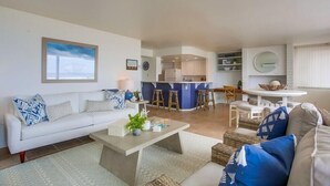 Ein modernes Wohnzimmer mit einer Couch, einem Couchtisch und einem Essbereich mit Tisch und Stühlen.
