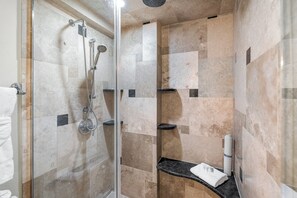 Een bad/douchecombinatie, een haardroger, handdoeken