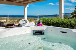 Un bain à remous offrant une vue dégagée sur l’océan et les collines en arrière-plan.