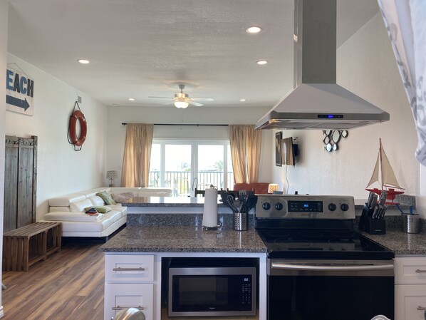 A modern kitchen with a microwave, stove, and dining area.