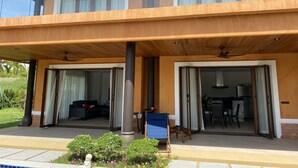 A modern two-story building with a covered outdoor area, large sliding glass doors, and a patio with seating. - Villa Tango with private Pool, Koh Yao Noi  (Ko Yao Noi)