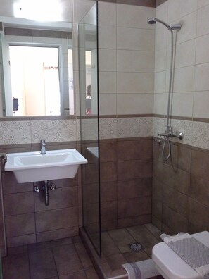 A bathroom with a sink, a shower, and a toilet.