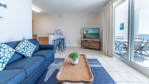 A modern living room with a sofa, coffee table, and a TV.