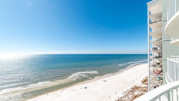 A beachfront hotel with balconies overlooking the ocean.