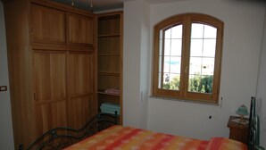 A bedroom with a bed, a wardrobe, and a window. - Vacation House in S. Maria di Leuca 900m from the sea (CASTRIGNANO DEL CAPO)