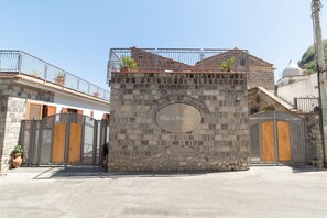 Mural de pedra com portão de metal e placa com a inscrição 'Olga's Residence'.