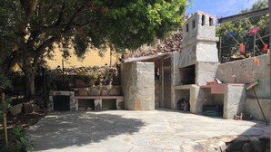 Un pati de pedra amb una banca de pedra i un mur de pedra.
