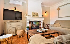 A living room with a fireplace, television, sofa, and coffee table.