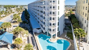 Un hotel de varios pisos con piscina, balcones y vistas del entorno.