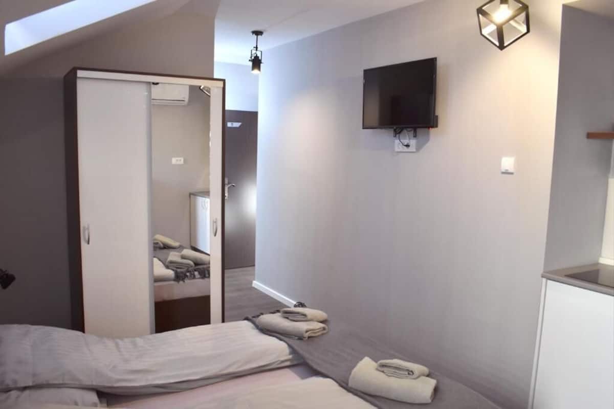 Une chambre d’hôtel comprenant un lit, une armoire, une télévision et un petit bureau.
