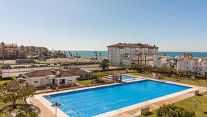 Una amplia piscina rodeada de edificios, con vistas al mar.