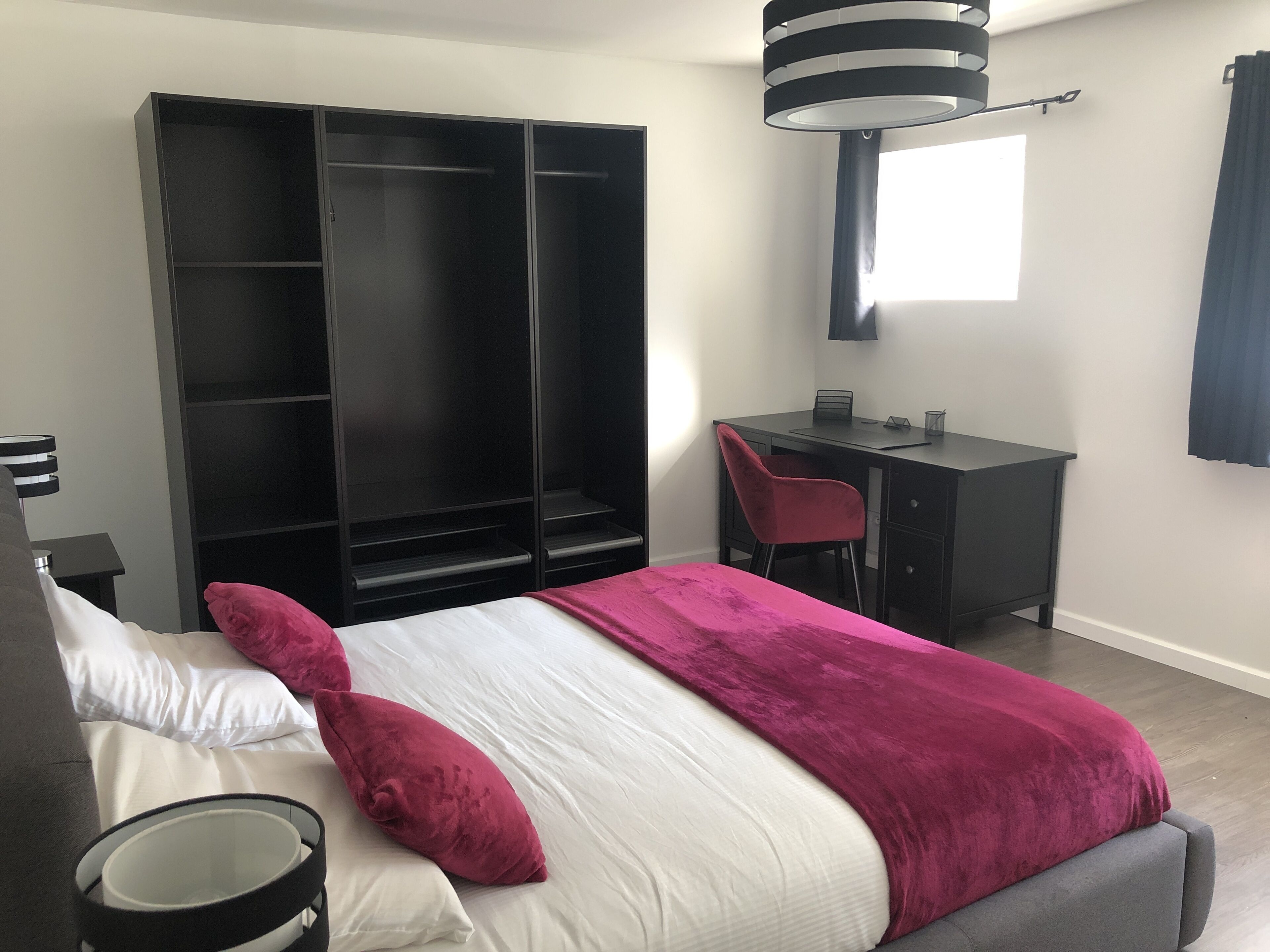Un dormitorio con cama, escritorio, silla y armario.