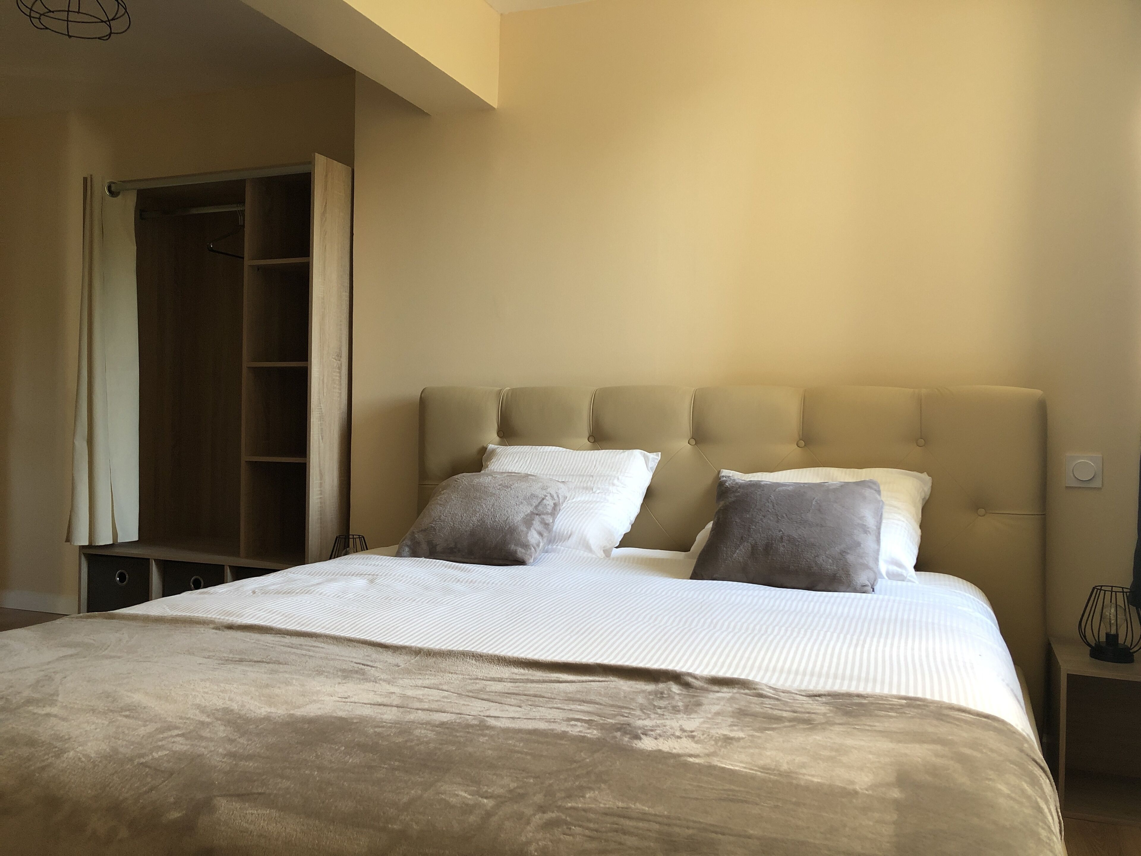 Una camera da letto con un letto, due cuscini, un comodino e un armadio.