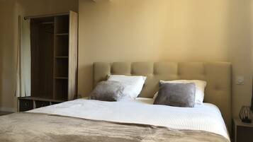 Una camera da letto con un letto, due cuscini, un comodino e un armadio.