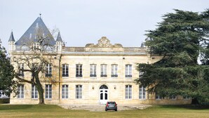 Ein großes, historisches Gebäude mit einer symmetrischen Fassade, zahlreichen Fenstern und einem markanten Eingang.
