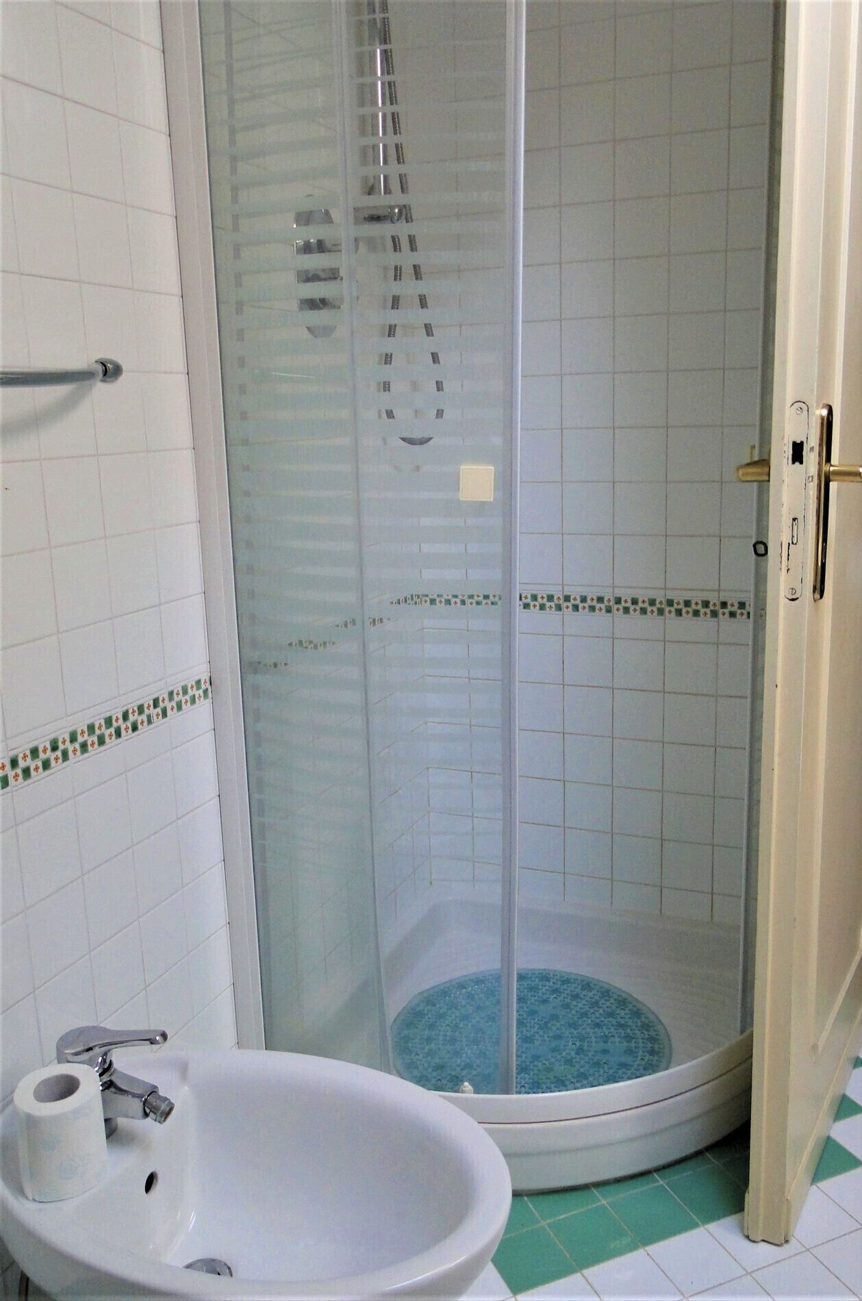 Une salle de bain avec une douche, un lavabo et des toilettes.