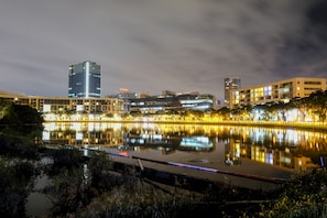 A nighttime cityscape with a calm lake reflecting buildings. - Jack Apartment Signature (Ho Chi Minh City)