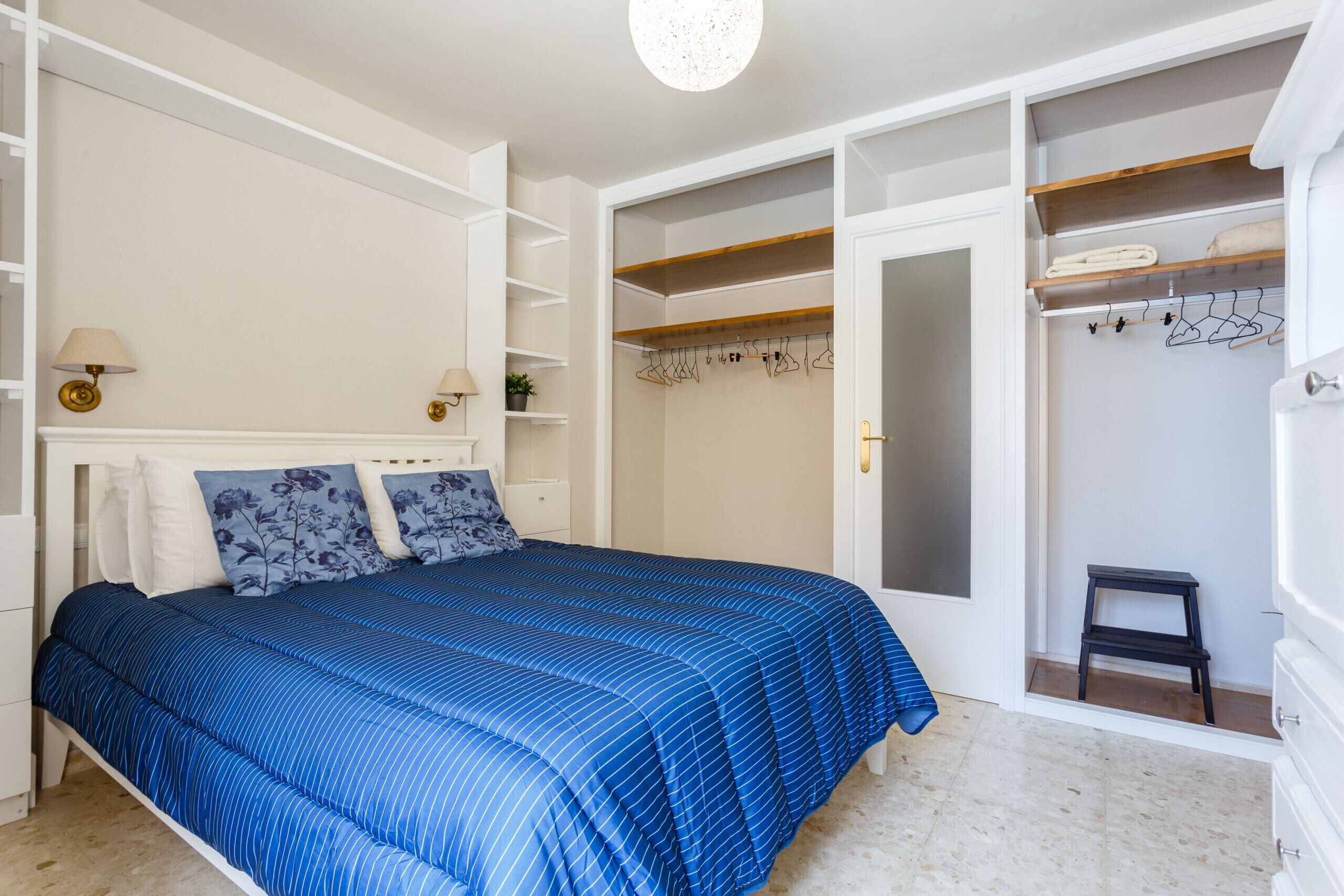 A bedroom with a bed, a wardrobe, and a nightstand.