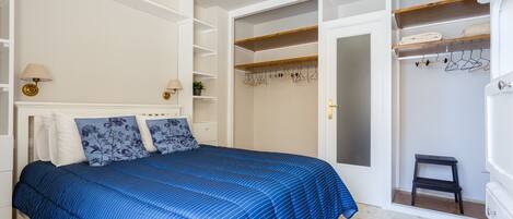 A bedroom with a bed, a wardrobe, and a nightstand.