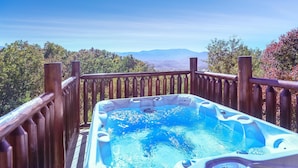 A hot tub on a wooden deck with a scenic mountain view. - Panoramic View - Suite 2: Brand New Hot Tub - Room w/ French Doors to Porch (sevierville)