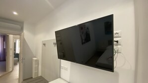 Une salle de bain moderne avec un grand miroir, des toilettes et un lavabo.
