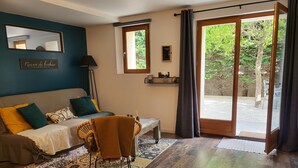 Une chambre confortable avec un lit, une chaise, une table de chevet et une fenêtre avec des rideaux.