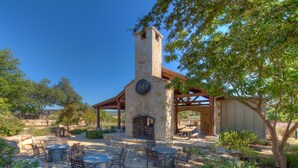 Un patio exterior con asientos y chimenea de piedra.