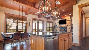 Una cocina amplia con una isla grande, armarios de madera y una chimenea de piedra.