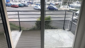 A balcony with a view of a marina and parked cars. - Magnifique F2 vue Port L'ostrea (Courseulles-sur-Mer)