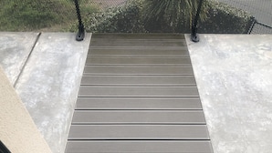 A set of outdoor steps leading to a covered area with a metal railing. - Magnifique F2 vue Port L'ostrea (Courseulles-sur-Mer)