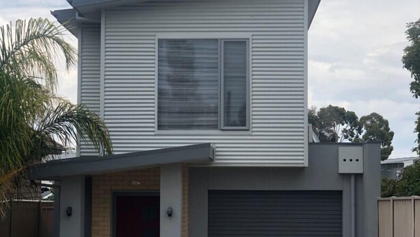 A two-story house with a garage, a front door, and a small porch area. - Modern Townhouse close to CBD (Bendigo)