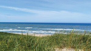 A beach with waves and grass in the foreground. - Awesome home in Blåvand with sauna (Blåvand)