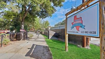 A sign for Wimberley Togg Cabins Resort Suites with a contact number and website.