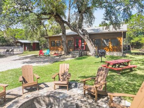 A cabin with outdoor seating and a barbecue area.