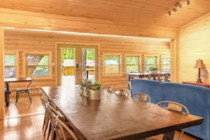 A wooden interior with a dining table, chairs, and a blue sofa.