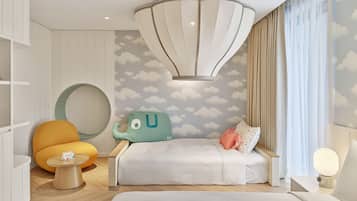 Een moderne slaapkamer met een bed, een ronde fauteuil, een klein tafeltje en een bijzondere lamp.