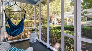 A covered porch with a hammock, wicker furniture, and a view of a garden and street. - Winter Discounts/ We love pets and they love our amenities (Summerville)