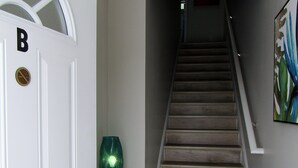 A staircase leading to a landing with a white door marked with a 'B' and a no smoking sign. - New Construction, Warm Coastal Feel, Home Away From Home
Covered Parking (Myrtle Beach)