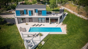 A modern two-story house with a swimming pool, outdoor seating, and a stone retaining wall. - Beautiful home in Barban (Barban)