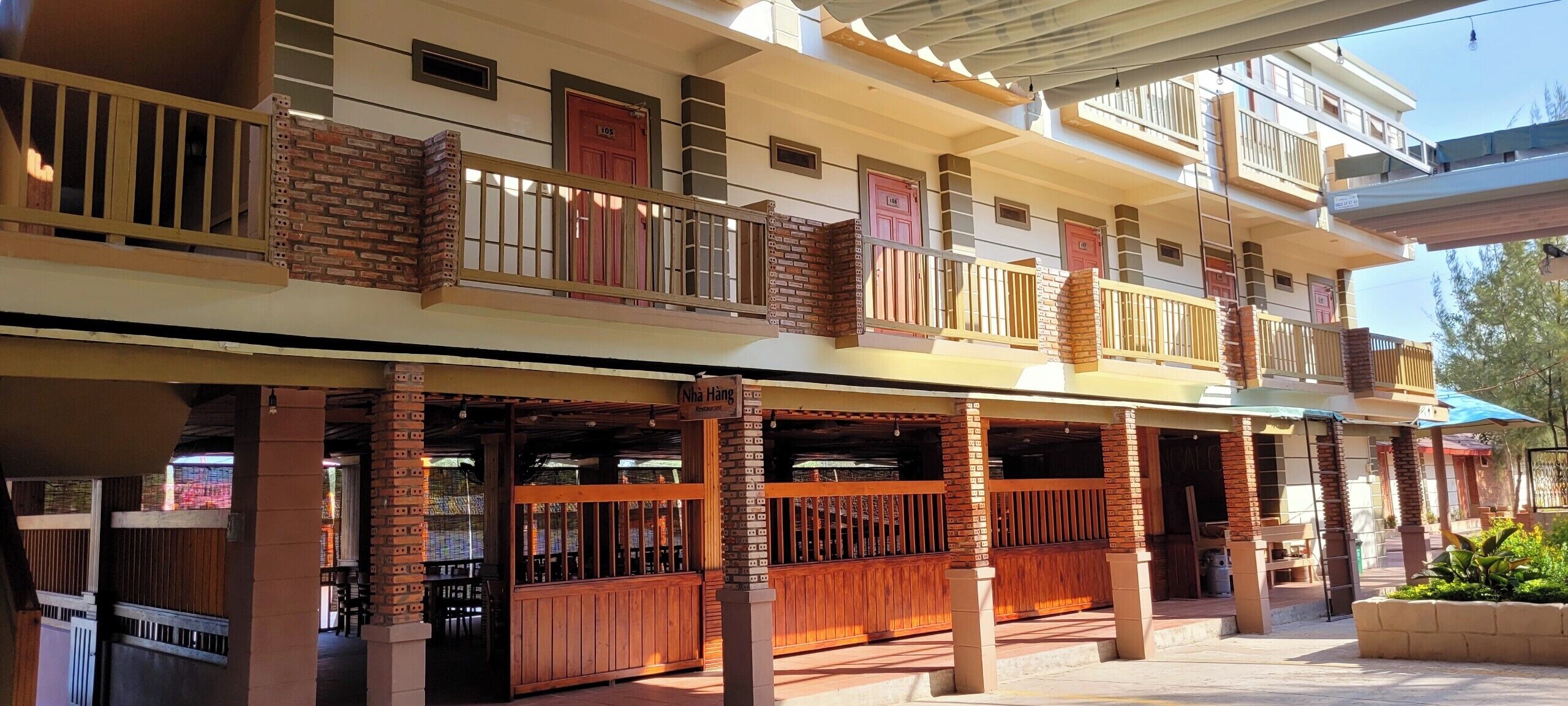 A multi-story building with a covered outdoor seating area and a restaurant sign.