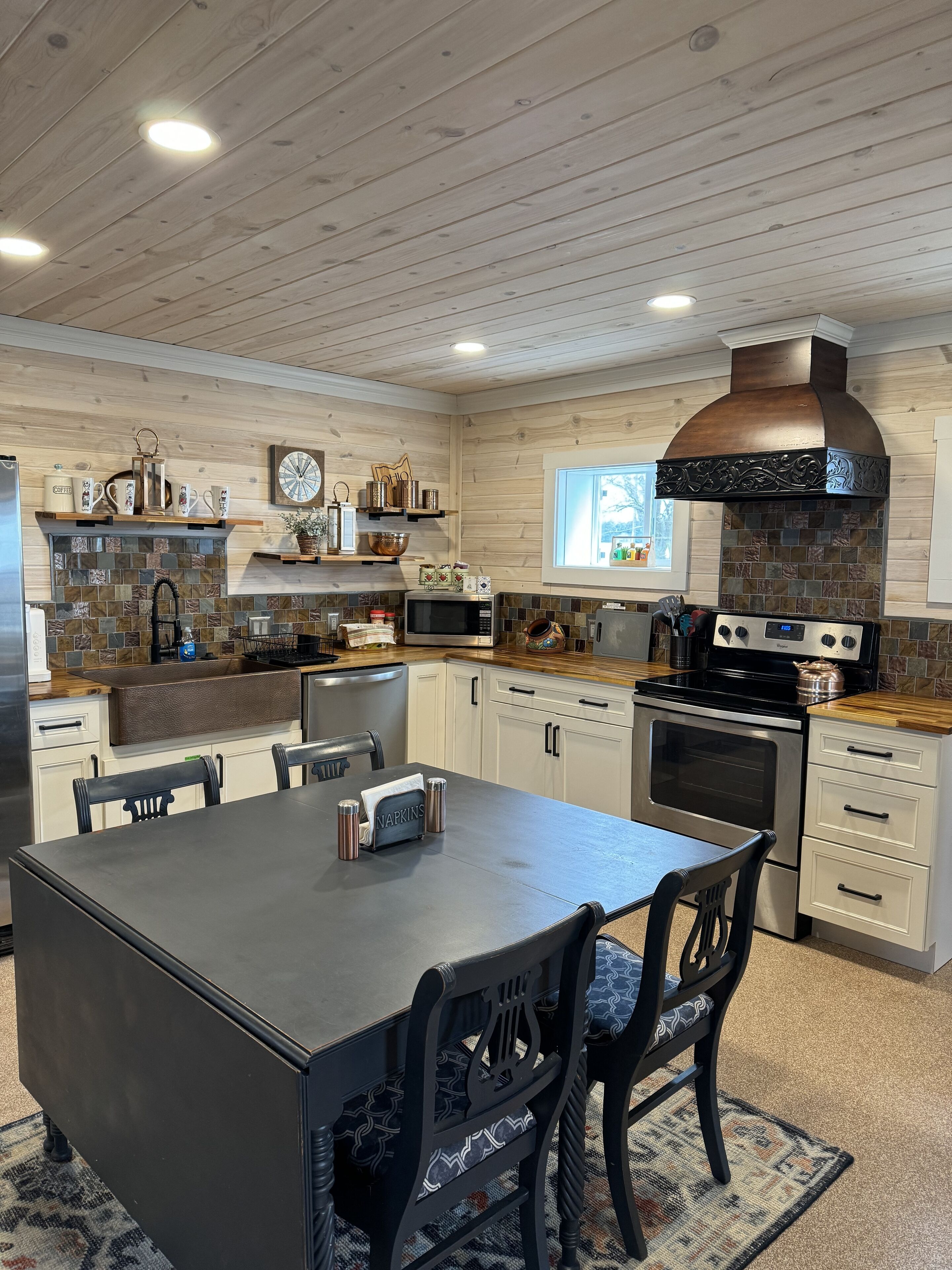 Een moderne keuken met houten kasten, een centraal eiland en een groot fornuis.