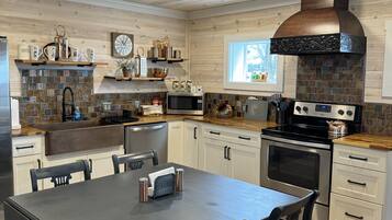 Een moderne keuken met houten kasten, een centraal eiland en een groot fornuis.