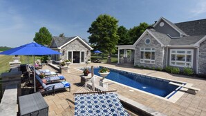 A poolside area with lounge chairs, umbrellas, and a stone building. - 2A2J Barn pool Getaway 9 miles to WEC (Wilmington)