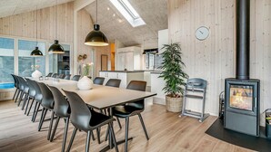 Eine moderne Küche mit weißen Schränken, einem schwarzen Herd und einem großen Fenster.