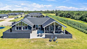 Ein modernes Haus mit einer großen Terrasse und einem Swimmingpool.