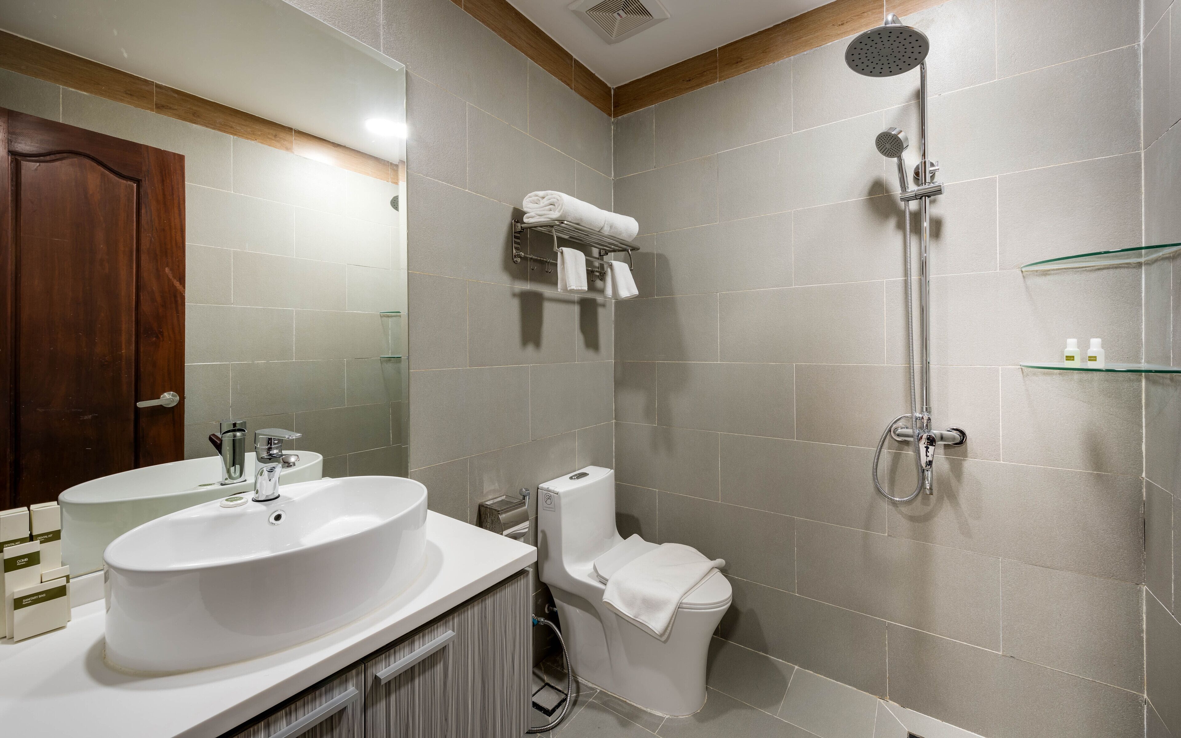 A modern bathroom with a large sink, toilet, and shower.