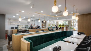 Una cafetería moderna con mostrador, zona de estar y cartelera de menú.