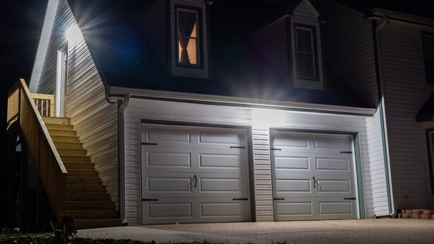 A two-story house with a garage, a staircase, and a window.