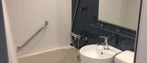 Un baño moderno con bañera, lavamanos e inodoro.