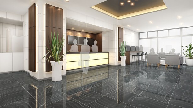 A modern reception area with a glass partition, a reception desk, seating area, and large windows. - Omura Station Hotel Nagasaki Airport (Omura)